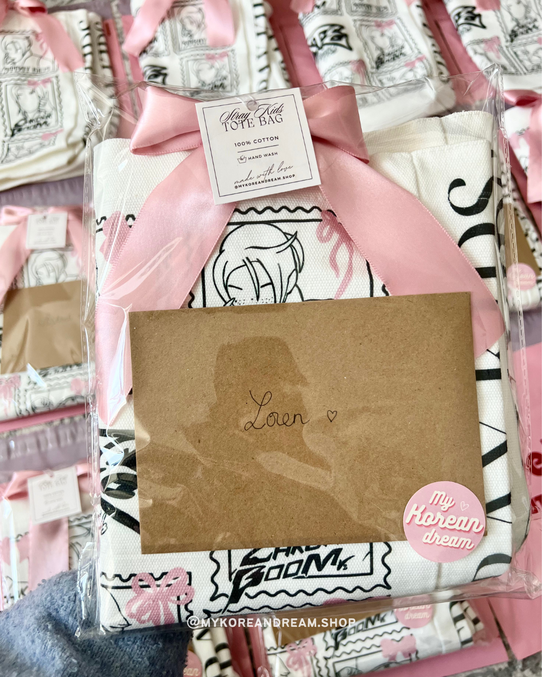 Focus sur l’étiquette cousue du tote bag, indiquant “100% coton - fait main avec amour”, ajoutant une touche artisanale au produit.